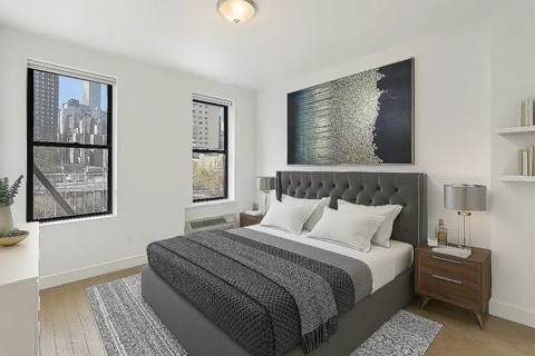 A bedroom with a large bed and a large picture on the wall.